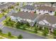 Overhead view of the townhome neighborhood featuring well-maintained lawns and convenient street access at 2214 Centerra Loop, Kissimmee, FL 34741