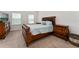 Spacious bedroom with an ornate wooden bed frame, plush carpet, and bright windows, offering a luxurious and restful atmosphere at 2214 Centerra Loop, Kissimmee, FL 34741