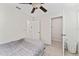 Neutral bedroom with a ceiling fan, a bed with grey linens, and access to a closet, perfect for a comfortable night's sleep at 2214 Centerra Loop, Kissimmee, FL 34741