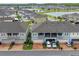 The exterior of a two-story townhome featuring a well-maintained lawn and brick driveway at 2214 Centerra Loop, Kissimmee, FL 34741