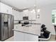 Bright kitchen features stainless steel appliances, granite countertops, and a stylish chandelier at 2214 Centerra Loop, Kissimmee, FL 34741
