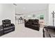Inviting living room with open-concept design, featuring a view of the modern kitchen and comfortable leather seating at 2214 Centerra Loop, Kissimmee, FL 34741