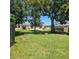 Well-maintained backyard lawn with mature trees and community pool in distance at 240 Windmeadows St # 240, Altamonte Springs, FL 32701