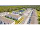 Aerial view of a townhome community featuring modern units, a central pond, and lush green surroundings at 2413 Brook Marsh Loop, Kissimmee, FL 34747
