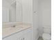 Half bathroom featuring a white vanity with quartz countertop, chrome faucet and a toilet at 2413 Brook Marsh Loop, Kissimmee, FL 34747