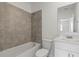 Modern bathroom features tile shower/bathtub, white vanity, and a large mirror at 2413 Brook Marsh Loop, Kissimmee, FL 34747
