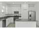Modern kitchen featuring stainless steel appliances, a center island, and white cabinets for storage at 2413 Brook Marsh Loop, Kissimmee, FL 34747