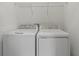 Efficient laundry room featuring a white washer and dryer with overhead shelving at 2413 Brook Marsh Loop, Kissimmee, FL 34747