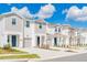 Charming townhomes with neutral paint, attached garages, professional landscaping under a blue sky with puffy clouds at 2413 Brook Marsh Loop, Kissimmee, FL 34747