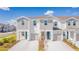 Close-up of townhomes with a mix of siding, attached garages, and stylish front doors and landscaping at 2413 Brook Marsh Loop, Kissimmee, FL 34747