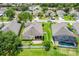 Aerial view of homes with manicured lawns, a community pool, and lush green landscaping at 2445 Cypress Trace Cir, Orlando, FL 32825