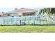 Lush green backyard view showcases a full white picket fence surrounding the property at 2445 Cypress Trace Cir, Orlando, FL 32825