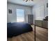 Bedroom with wood floor, large window, blinds, ceiling fan, dresser, and bed with blue comforter at 2445 Cypress Trace Cir, Orlando, FL 32825
