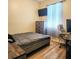 Bedroom with wood floor, large window with sheer curtains, and bed with gray comforter at 2445 Cypress Trace Cir, Orlando, FL 32825
