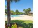 Community pool with clear blue water, lounge chairs, palm trees, and pergola at 2445 Cypress Trace Cir, Orlando, FL 32825