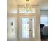 Elegant front door with decorative glass panel and modern chandelier, offering a bright entry at 2445 Cypress Trace Cir, Orlando, FL 32825