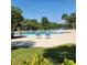 Sparkling community pool with comfortable lounge chairs and lush landscaping under a clear blue sky at 2445 Cypress Trace Cir, Orlando, FL 32825