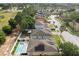 Aerial view of a neighborhood highlighting the property's backyard with a pool and solar panels at 252 Elgin Blvd, Davenport, FL 33897