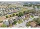 An aerial view showcases properties, some equipped with solar panels, in a neighborhood close to a major highway at 252 Elgin Blvd, Davenport, FL 33897