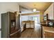 Open kitchen featuring stainless steel refrigerator, wood-look floors, and view to the living area at 252 Elgin Blvd, Davenport, FL 33897