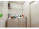 Bright laundry room features a washer, dryer, overhead shelving, and convenient access to storage and other household essentials at 252 Elgin Blvd, Davenport, FL 33897