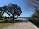 Beautiful waterfront walkway leading to a gazebo and beach, framed by lush greenery and mature trees at 2532 Waterview Pl, Windermere, FL 34786