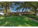 Charming brick home featuring a lush green lawn, mature trees, and a welcoming front entrance at 2609 Chinook Trl, Maitland, FL 32751