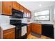 Kitchen features wooden cabinetry, black appliances, and laminate countertops at 2609 Chinook Trl, Maitland, FL 32751