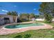 A backyard showcasing a sparkling pool area with lush green grass, bordered by a classic red brick patio at 2609 Chinook Trl, Maitland, FL 32751