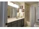 Well-lit bathroom with framed art, gray vanity, white sink, and shower-tub combo at 2618 Lodi Cir # 102, Kissimmee, FL 34746