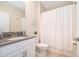 Bright bathroom showcasing a vanity with a grey countertop and a shower with white curtain at 2771 Oxymoron Way, Kissimmee, FL 34746