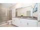 Modern bathroom highlighting double sinks with quartz countertop and a glass-enclosed shower at 2771 Oxymoron Way, Kissimmee, FL 34746