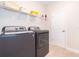 Functional laundry room equipped with a washer, dryer, and storage shelves at 2771 Oxymoron Way, Kissimmee, FL 34746