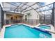 Outdoor pool area featuring a swimming pool, jacuzzi, and a screened enclosure at 2771 Oxymoron Way, Kissimmee, FL 34746