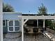 Backyard area with an outdoor grill and bar under a pergola, ideal for entertaining and relaxing at 3067 Ne 102Nd Avenue Rd, Silver Springs, FL 34488