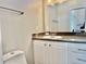 Well-lit bathroom featuring a vanity with white cabinets and a countertop with a tile backsplash at 3067 Ne 102Nd Avenue Rd, Silver Springs, FL 34488