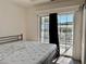 Bedroom featuring a bed, sliding glass doors to a private balcony, and natural light at 3067 Ne 102Nd Avenue Rd, Silver Springs, FL 34488