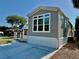 Single-Gathering home featuring large windows and a concrete driveway, providing ample parking at 3067 Ne 102Nd Avenue Rd, Silver Springs, FL 34488