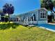 Charming gray single Gathering home featuring a nice black and white deck and a well-manicured lawn at 3067 Ne 102Nd Avenue Rd, Silver Springs, FL 34488
