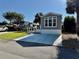 Gray single-Gathering home with a front concrete driveway and well-manicured lawn on a sunny day at 3067 Ne 102Nd Avenue Rd, Silver Springs, FL 34488
