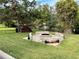 Inviting outdoor fire pit area featuring brick surround and views of pond with fountain at 3067 Ne 102Nd Avenue Rd, Silver Springs, FL 34488
