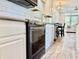 Well-equipped kitchen with stainless appliances, white cabinets, tile backsplash, and stylish wood flooring at 3067 Ne 102Nd Avenue Rd, Silver Springs, FL 34488