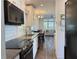 Modern kitchen features stainless appliances, white cabinets and a view into the living area at 3067 Ne 102Nd Avenue Rd, Silver Springs, FL 34488