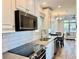 Bright kitchen with white cabinets, stainless appliances, stone countertops, and a view into the living space at 3067 Ne 102Nd Avenue Rd, Silver Springs, FL 34488