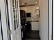 View of the open kitchen with white cabinets, black appliances and dark wood floors at 3067 Ne 102Nd Avenue Rd, Silver Springs, FL 34488