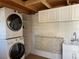 Bright laundry area features stacked washer/dryer, folding table, sink and overhead cabinets at 3067 Ne 102Nd Avenue Rd, Silver Springs, FL 34488