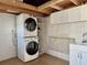 Laundry room features stacked washer and dryer, sink, cabinets, folding counter, and shelves at 3067 Ne 102Nd Avenue Rd, Silver Springs, FL 34488