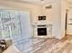 Cozy living room with modern fireplace, decorative tile surround, wood-look floors, and sliding glass door at 3067 Ne 102Nd Avenue Rd, Silver Springs, FL 34488