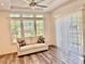 Bright living room with a comfortable couch, large windows, sliding glass doors, and wood-look floors at 3067 Ne 102Nd Avenue Rd, Silver Springs, FL 34488