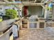Stylish outdoor kitchen featuring bar seating, tile countertops, and an overhead pergola perfect for entertaining at 3067 Ne 102Nd Avenue Rd, Silver Springs, FL 34488